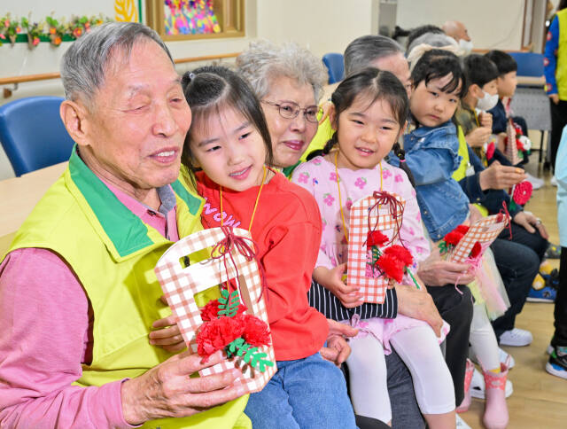 어버이날을 하루 앞둔 7일 오전 수원특례시 팔달구 팔달노인복지관에서 관내 어린이집 아이들이 어르신들에게 카네이션을 달아드린 뒤 포옹하고 있다. 윤원규기자