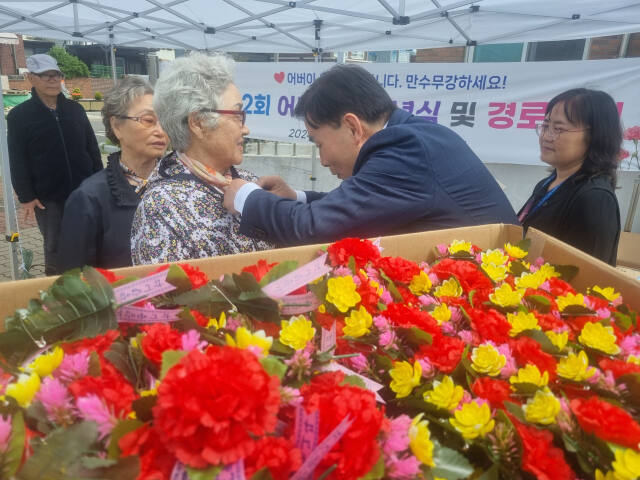문경복 인천 옹진군수가 8일 연평면에서 열린 어버이날 기념행사에서 지역 어르신에게 카네이션을 달고 있다. 군 제공