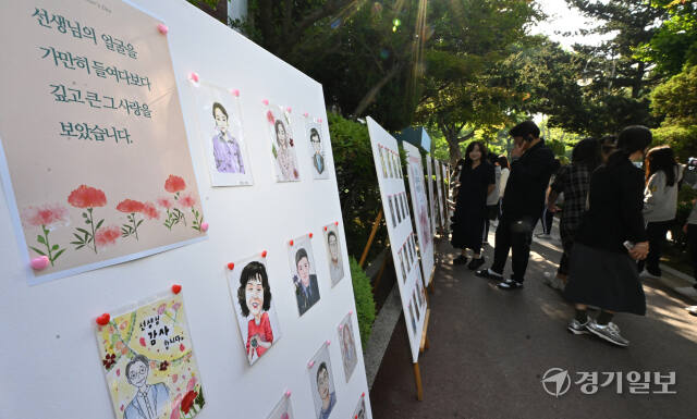 스승의 날을 하루 앞둔 14일 오전 인천 미추홀구 인명여자고등학교에서 선생님들이 자신들의 캐리커처를 감상하고 있다. 조병석기자