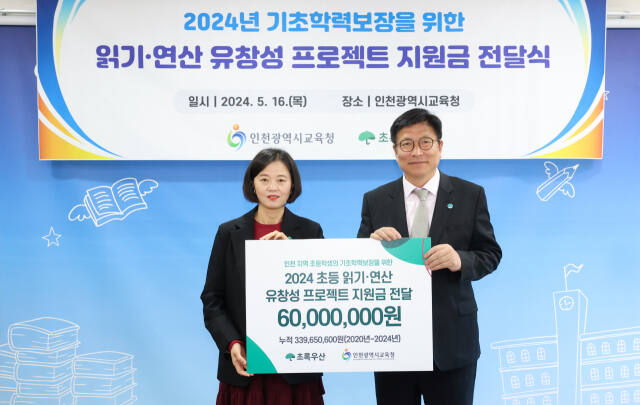 이서영 초록우산어린이재단 인천지역 본부장(왼쪽)이 인천시교육청에 초등학생 기초학력보장을 위한 유창성 프로젝트 지원금 6천만 원을 전달한 뒤 도성훈 인천시교육감과 기념촬영을 하고 있다. 초록우산 어린이재단 제공
