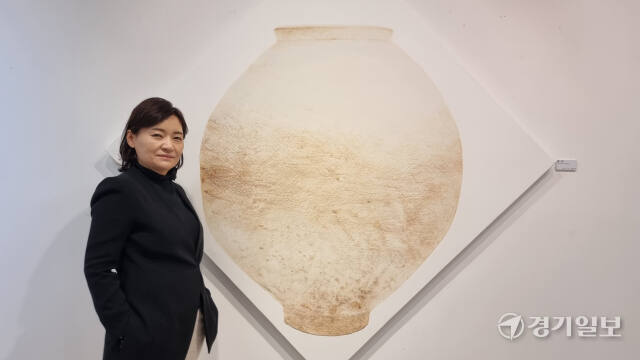 오는 19일까지 제2회 수원전통문화관 기획전시실(진수원) 연작 초대전의 두번째 전시회 ‘품·다’가 열리는 가운데 이동숙 작가가 달항아리를 소재로 한 자신의 채색화 작품 앞에서 사진 촬영을 하고 있다. 이나경기자