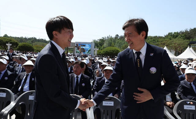 이준석 대표(왼쪽)가 18일 5·18민주묘지에서 열린 제44주년 5·18민주화운동 기념식에서 조국 대표와 만나 악수하고 있다. 연합뉴스