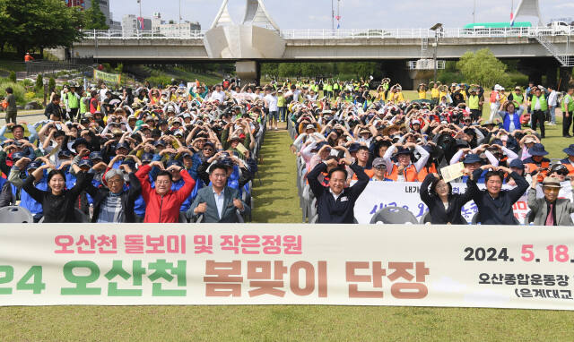 이권재 오산시장이 지난 18일 오산천 둔치에서 열린 ‘작은 정원 봄맞이 단장 행사’’에서참석자들과 기념사진을촬영하고 있다. 오산시 제공