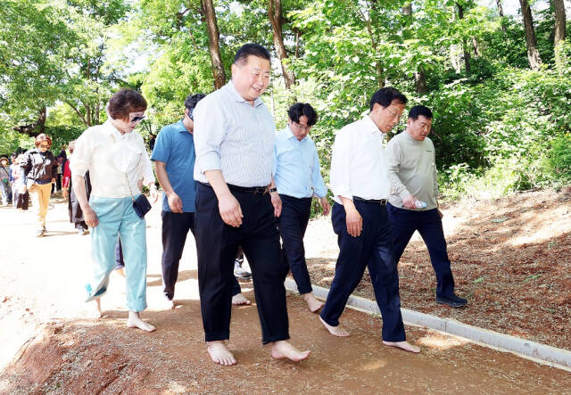 김경일 파주시장이 시민들과 맨발로 운정3동 새암공원 내 황토로 조성한 맨발걷기 길을 걷고 있다. 파주시 제공