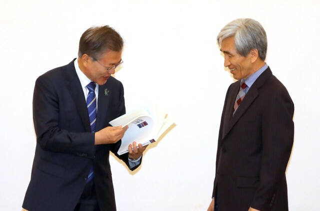 문재인 대통령이 2018년 3월 13일 청와대에서 열린 국민헌법자문특별위원회 정해구 위원장(오른쪽)으로부터 개헌과 관련한 자문안을 전달받고 있다. 연합뉴스
