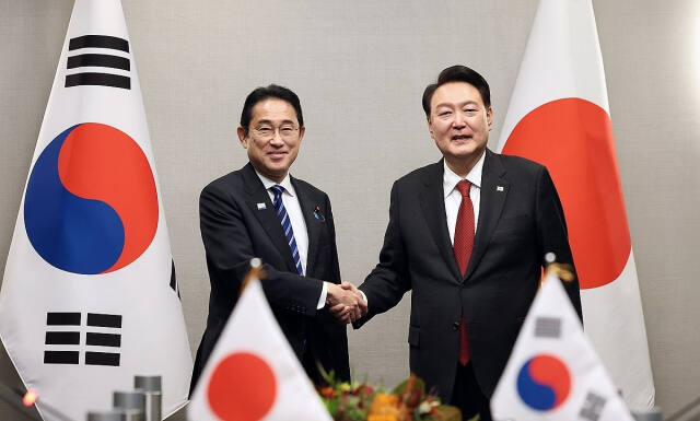 지난해 1월 기시다 일본 총리와 악수하는 윤석열 대통령. 연합뉴스