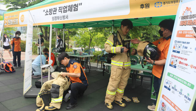 의정부소방서가 최근 운영한 체험부스에서 청소년과 시민들이 화재진압복 착용 체험을 하고 있다. 의정부소방서 제공