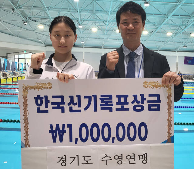 제53회 전국소년체전 수영 여중부 배영 50m에서 한국신기록을 수립한 김승원(왼쪽)에게 김범준 경기도수영연맹 회장이 포상금을 전달하고 있다.황선학기자