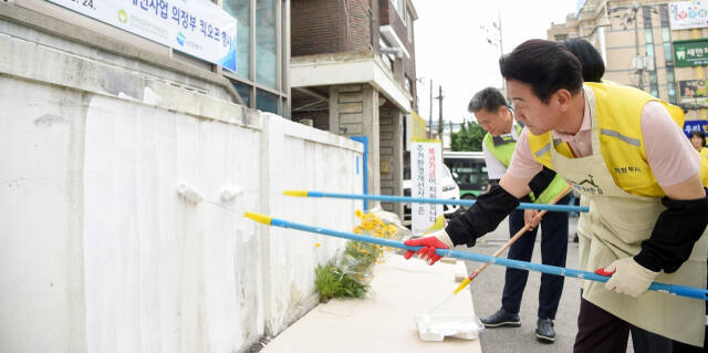 김동근 의정부시장이 27일 의정부시 녹양동에서 열린 ‘국가유공자 주거환경 개선사업을 위한 킥오프 행사’에서 참석자들과 국가유공자 주택 벽에 페인트 도색작업을 하고 있다. 의정부시 제공