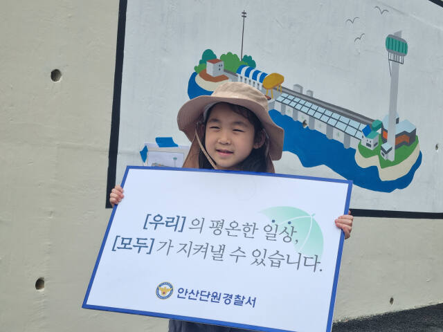 벽화가 그려진 선부3파출소를 찾은 어린이가 단원서에서 제작한 ‘평온한 일상 지키기’ 표지판을 들고 기념 촬영을 하고 있다. 독자 제공