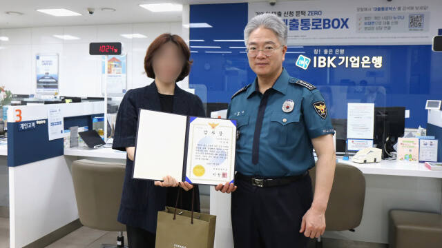 30일 이창영 의왕경찰서장(오른쪽)이 보이스피싱 피해를 예방한 기업은행 직원에게 감사장을 전달했다. 의왕경찰서 제공