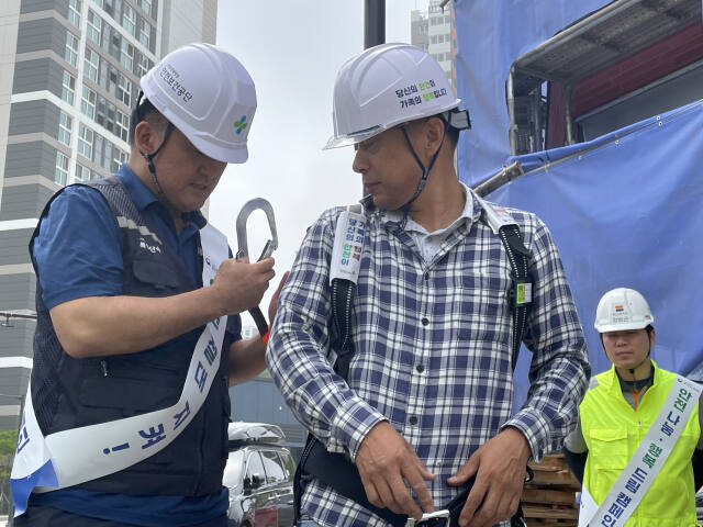 안전보건공단 직원이 건설현장 근로자를 대상으로 안전대 착용법을 설명하고 있다. 이대현기자
