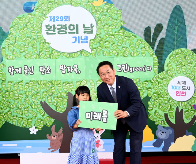 유정복 인천시장이 최근 환경의 날을 기념해 열린 행사에서 한 어린이와 사진을 찍고 있다. 인천시 제공