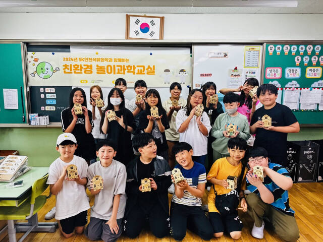 SK인천석유화학 친환경 놀이과학교실에 참여한 인천 서구 신석초등학교 5학년 학생들이 직접 태양광 조명을 만들고 기념촬영을 하고 있다. SK인천석유화학 제공