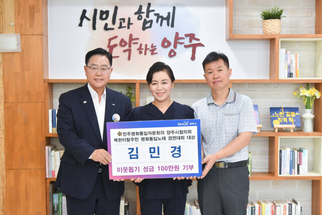 북한이탈주민 평화통일노래 경연대회에서 대상을 받은 김민경씨(가운데)가 상금 전액을 양주시에 기부한 뒤 강수현 양주시장(왼쪽)과 기념촬열을 하고 있다. 양주시 제공