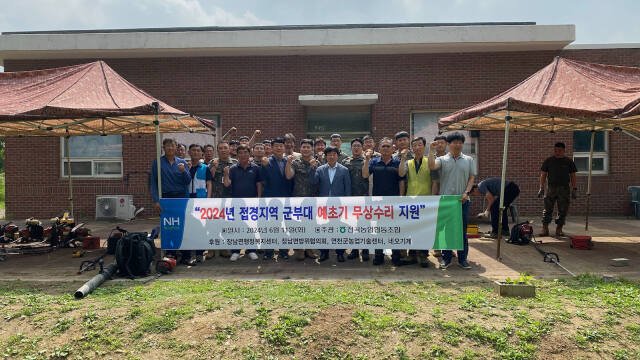 연천군 장남면 관계자들이 11일 관할 군부대를 방문해 예초기를 무상수리하고 기념촬영을 하고 있다. 연천군 제공