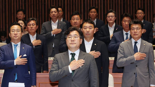 더불어민주당 박찬대 원내대표와 진성준 정책위의장 등 의원들이 13일 오전 서울 여의도 국회에서 열린 정책 의원총회에서 국기에 경례하고 있다. 연합뉴스