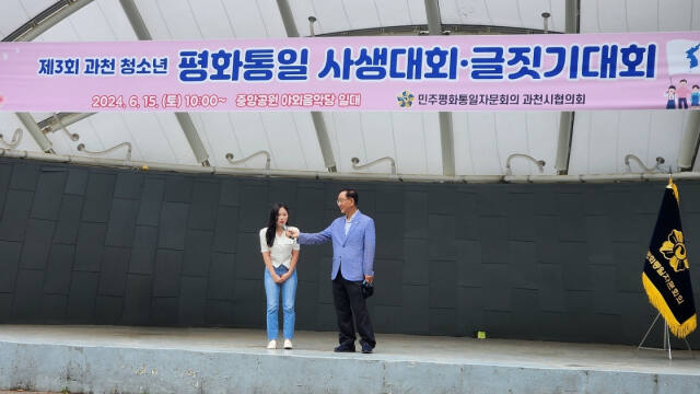 15일 열린 ‘제3회 과천 청소년 평화통일 사생·글짓기대회’에서 김수림양(왼쪽)과 이순형 민주평화통일자문회의 과천시협의회장이 무대에 올라서 있다. 민주평통 제공
