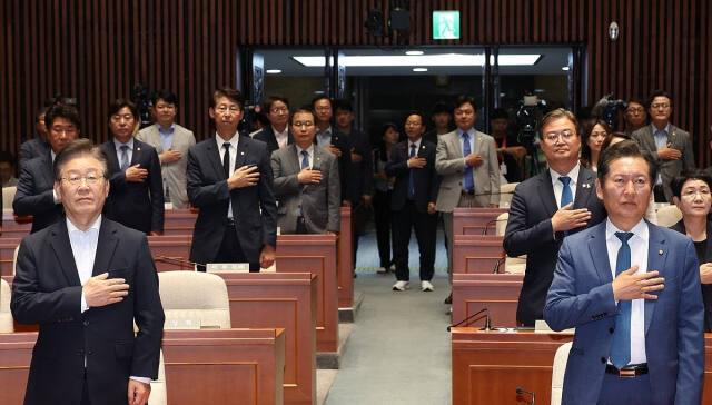 더불어민주당 이재명 대표와 정청래 법사위원장이 지난 11일 국회에서 열린 의원총회에서 국기에 대한 경례를 하고 있다. 연합뉴스