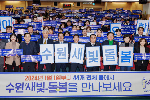 지난해 12월 수원특례시 관계자들이 수원새빛돌봄 전체 동 확대를 홍보하는 손팻말을 들어 보이고 있다. 수원특례시 제공