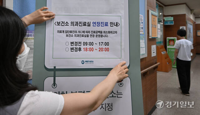 대한의사협회가 집단 휴진에 나선 18일 인천 부평구 부평보건소에서 직원이 의과진료실 연장진료를 알리는 안내문을 붙이고 있다.조병석기자
