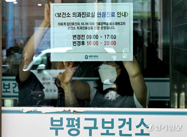 대한의사협회가 집단 휴진에 나선 18일 인천 부평구 부평보건소에서 직원들이 의과진료실 연장진료를 알리는 안내문을 붙이고 있다.조병석기자
