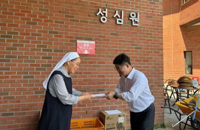 18일 오전 용인 수지구 아동보육시설 성심원에서 김 아델라 원장에게 박윤근 국민건강보험공단 용인서부지사장(오른쪽)이 임직원들이 모은 수익금과 기금 등을 기탁하고 있다. 국민건강보험공단 용인서부지사 제공