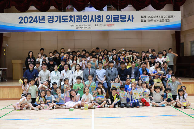 경기도치과의사회가 20일 양주시치과의사회와 함께 양주시 상수초등학교를 찾아 의료봉사를 한 뒤 학생들과 기념촬영을 하고 있다. 경기도치과의사회 제공