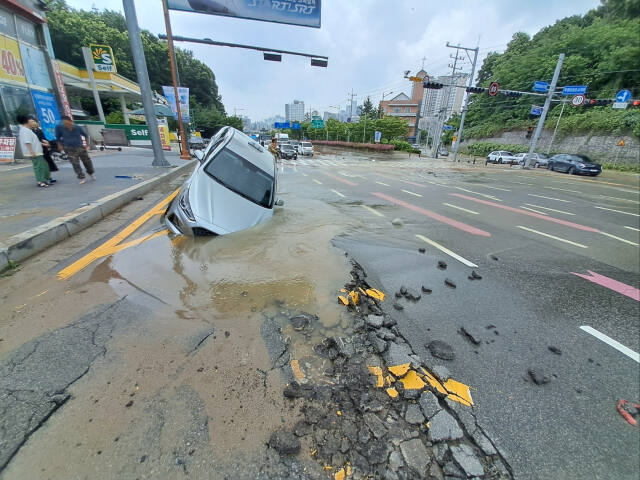 평택시 이충동 수도관 파열로 인한 땅꺼짐으로 택시가 구덩이에 빠진 사고현장. 송탄소방서 제공