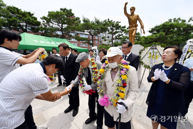 6.25전쟁 제74주년인 25일 오전 수원고에서 열린 6.25 참전기념비 헌화식에서 학생대표가 선배인 학도병 참전용사에게 꽃목걸이를 전달하고 있다. 김시범기자