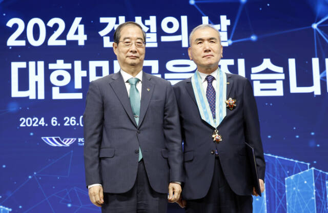 이상민 신정건설 대표(오른쪽)가 2024 건설의 날 기념식에서 은탑산업훈장을 받은 뒤 한덕수 국무총리와 기념촬영을 하고 있다. 본인 제공