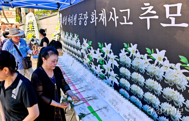 27일 오후 안산시 단원구 원곡동 다문화어린이공원에 중국동포 단체가 마련한 화성 리튬 배터리 공장 화재 희생자들을 추모하는 추모분향소에서 참석자들이 희생자들의 이름에 헌화하고 있다. 윤원규기자