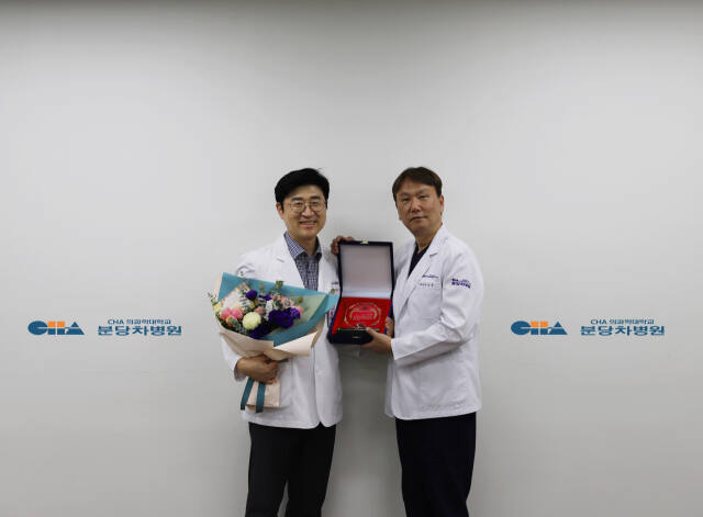 정상윤 분당차병원 류마티스내과 교수(왼쪽)가 환자경험 우수 의사 1위로 선정된 후 윤상욱 분당차병원장에게 상을 전달받고 있다. 분당차병원 제공