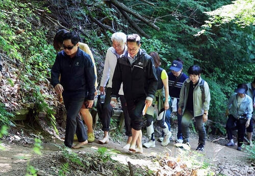 남양주시가 내년 3월까지 총연장 11.3㎞의 맨발걷기 길을 조성한다. 주광덕 남양주시장이 직원들과 맨발걷기 길을 걸어가고 있다. 남양주시 제공