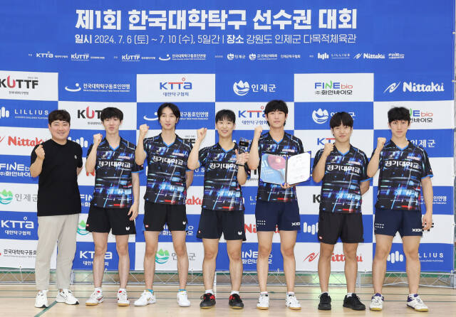 제1회 한국대학탁구선수권대회 남자 단체전서 원년 챔피언에 오른 경기대 이재욱 감독(왼쪽)과 선수들이 기념촬영을 하고 있다.월간탁구 제공