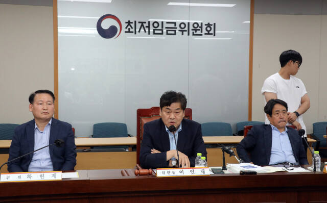 이인재 최저임금위원장(가운데)이 지난 12일 새벽 정부세종청사에서 제11차 전원회의가 끝난 뒤 취재진의 질문에 답변하고 있다. 연합뉴스