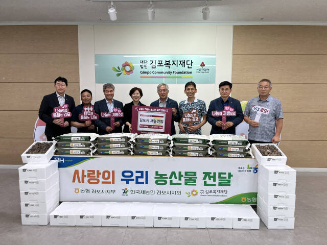 농협 김포시지부와 한국새농민회 김포시지회가 우리 농산물을 김포복지재단에 전달하고 기념사진을 촬영하고 있다. 농협 김포시지부 제공