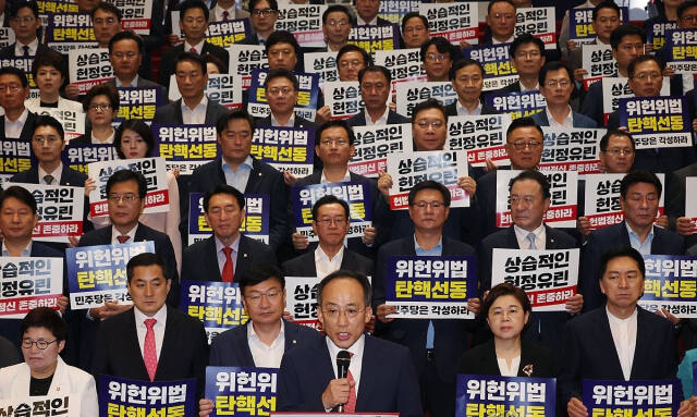 국민의힘 추경호 원내대표와 의원들이 17일 제헌절 경축식 행사 준비가 한창인 국회 로텐더홀 계단에서 '더불어민주당 의회독재 규탄대회'를 하고 있다. 연합뉴스