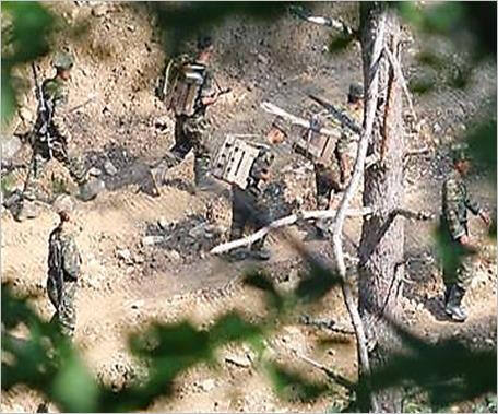 DMZ 북측 지역서 지뢰 운반 중인 북한군. 정확한 촬영일자는 공개되지 않았다. 연합뉴스