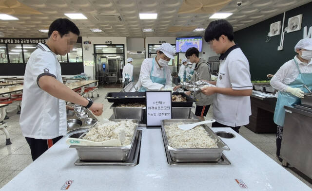 자율선택급식 실천학교로 선정된 화성 동탄중에서 17일 학생들이 자율배식으로 밥을 식판에 담고 있다. 김한울기자