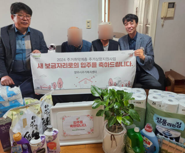 차순범 양주시 도시재생과장(오른쪽 첫번째)과 백승호 백석읍장 등이 주거취약계층 주거상향 지원사업 1호 주택 입주자를 찾아 입주 축하물품을 전달하고 기념사진을 촬영하고 있다. 양주시 제공