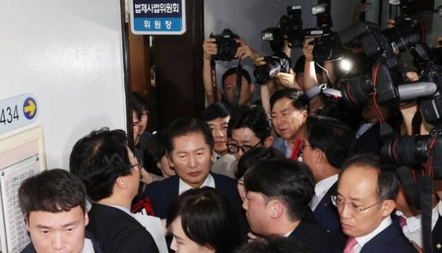 정청래 국회 법제사법위원회 위원장이 국민의힘 의원들의 항의를 받으며 19일 오전 ‘윤석열 대통령 탄핵소추안 발의 요청’ 국민동의 청원 청문회가 열리는 회의장으로 향하고 있다. 연합뉴스
