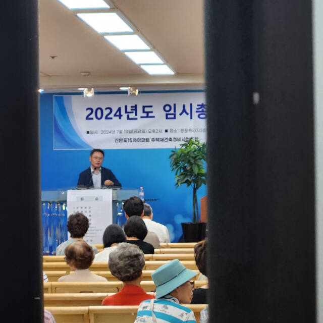 19일 서울 서초구 반포프라자에서 열린 신반포15차 조합 임시총회에서 조합장이 58억원 성과급 내역을 설명하고 있다. 하재인 기자