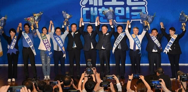 14일 오후 서울 여의도 국회도서관 대강당에서 열린 더불어민주당 8·18 전당대회 최고위원 예비경선. 3명의 대표 후보와 이날 컷오프를 통과한 8명의 최고위원 후보들이 손을 들어 올리며 당원들에게 인사하고 있다. 왼쪽부터 전현희·한준호·강선우·정봉주 최고위원 후보, 김두관·김지수·이재명 대표 후보, 김민석·민형배·김병주·이언주 최고위원 후보. 연합뉴스