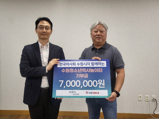 이광희 수원YMCA 사무총장(왼쪽)이 조영진 한국마사회 수원지사장으로부터 기부금을 전달받고 기념 촬영을 하고 있다. 수원YMCA 제공