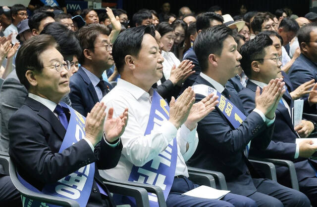 더불어민주당 새 지도부 선출을 위한 전당대회를 앞두고 20일 제주시 한라체육관에서 열린 합동연설회에서 이재명·김두관·김지수 대표 후보(왼쪽부터)가 나란히 앉아 손뼉을 치고 있다. 연합뉴스