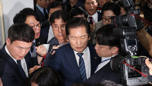 정청래 국회 법제사법위원회 위원장이 국민의힘 의원들의 항의를 받으며 19일 오전 '윤석열 대통령 탄핵소추안 발의 요청' 국민동의 청원 청문회가 열리는 회의장으로 향하고 있다. 연합뉴스
