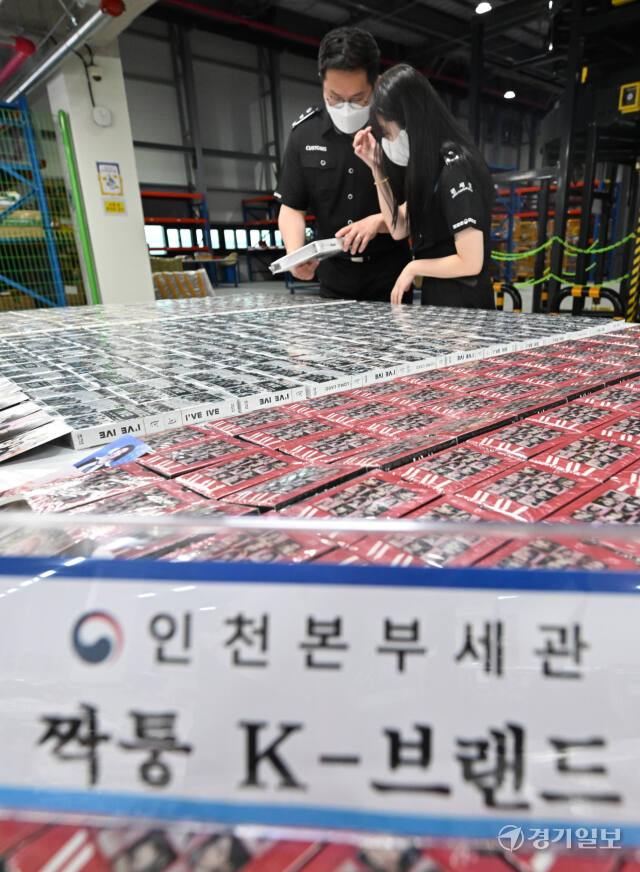23일 인천 연수구 인천본부세관 통합검사센터 해상특송물류센터에서 인천세관 관계자들이 K-팝 아이돌 포토 카드, 위조 명품 등 중국발 짝퉁 반입 물품을 살펴보고 있다. 조병석기자