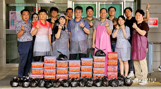 23일 오전 용인특례시 기흥구 기흥동행정복지센터에 모인 삼성전자·용인 소통협의회 위원들이 김장김치 봉사를 진행한 뒤 기념촬영을 하고 있다. 송상호기자