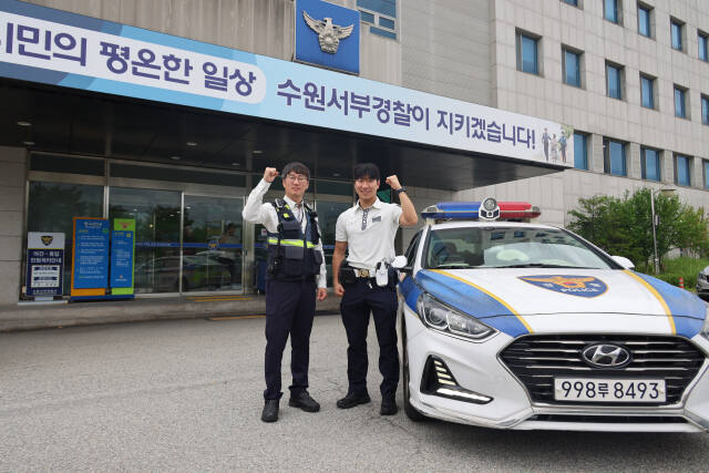 의식 잃은 운전자를 살린 수원서부경찰서 교통관리계 남상원 경위와 우한얼 순경이 기념촬영을 하고 있다. 수원서부서 제공